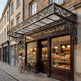 Bakery and cafe with decorative awning and display of bread and pastries.