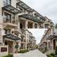 Row of townhouses with decorative canopies and well-maintained gardens.