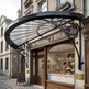 Heritage iron awning featuring radiating supports and decorative scroll brackets.
