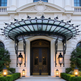 Wrought iron scrollwork canopy installed above double wooden door.