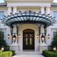 Lantern‑lit glass and iron canopy providing weather protection at building entrance.