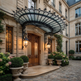 Lantern‑lit glass and iron canopy providing weather protection at building entrance.