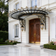 Ornate entrance canopy featuring dual lanterns and arched glass top.