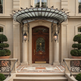 Wrought iron and glass canopy mounted above exterior doorway with scrollwork.