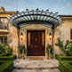 Architectural entrance canopy featuring wrought iron scroll brackets and glass panel.