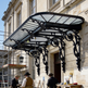 Glass and iron arched canopy with lantern lighting at exterior doorway.