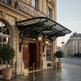 Ornate iron scrollwork awning providing weather protection at hotel‑style entrance.