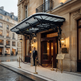 Curved glass canopy supported by decorative wrought iron brackets and lanterns.