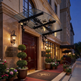 Glass and iron canopy with floral scrollwork and hanging lantern fixtures.