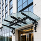 Decorative outdoor canopy featuring floral ironwork and dual lantern lights.