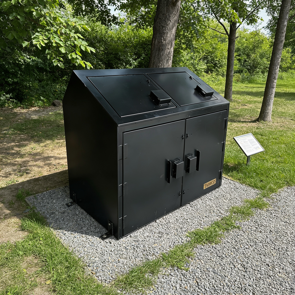 Metal trash bin with two lids in a park setting