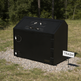Black outdoor trash bin with a 'TRASH' sign in a natural setting