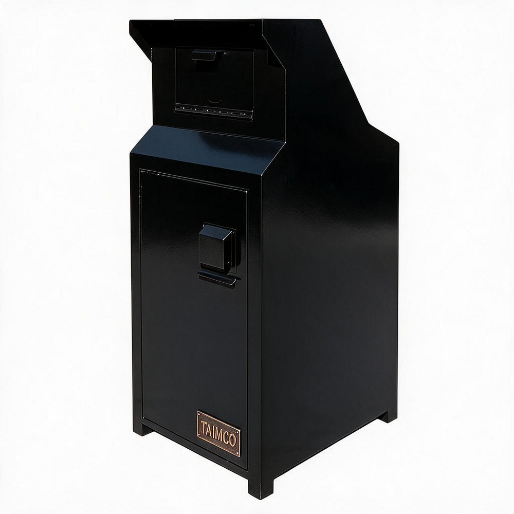 A black TAMCO cash drawer safe with a front door, handle, and a top dispensing slot, shown on a plain white background.
