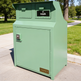 Green trash bin with 'Taimco' branding in a park setting