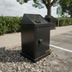 Commercial outdoor waste bin featuring sturdy construction and front clean‑out door