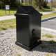 Durable steel trash bin designed with angled opening and compact front door