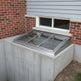 Basement window with concrete sill and brick wall