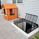 Powder‑coated steel window well grate with welded round‑bar grid and reinforced frame for basement safety and ventilation.