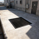 Powder‑coated steel window well grate with welded round‑bar grid and reinforced frame for basement safety.