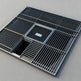 Metal grid drain cover on a gray background