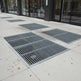 Metal grates on a sidewalk in an urban setting