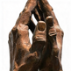 Wooden sculpture of a hand holding a shoe on a white background
Textured metallic hands pressed together on a solid base