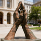 Bronze sculpture of interlocking hands in front of a building
Textured bronze artwork depicting large praying hands