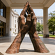 Bronze sculpture of interlocked hands in a public square with classical 
architecture.
Realistic bronze hands sculpture symbolizing unity and reverence.